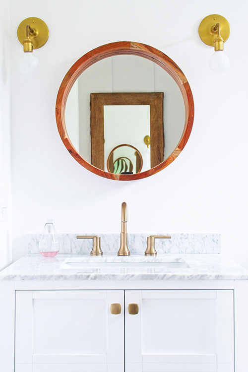 farmhouse bathroom round wood mirror brass wall sconce gold brass faucet hardware bath vanity