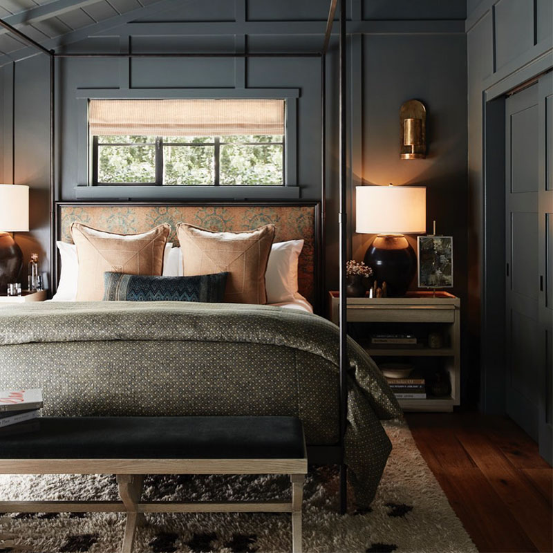dark gray moody bedroom with board and batten walls and iron four poster bed designed by John De Bastiano Interiors