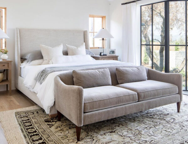 Studio McGee Crestview House velvet sofa in front of upholstered wingback king size bed and vintage Turkish rug